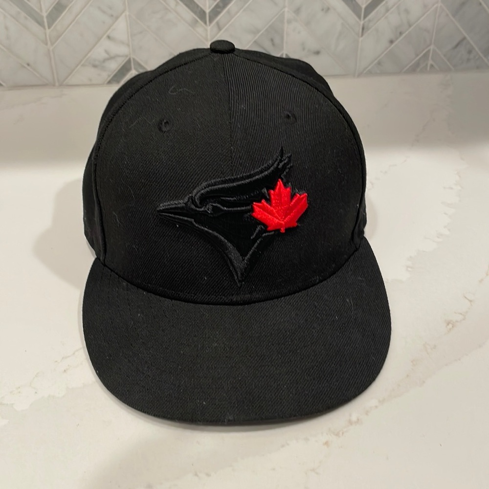 Blacked out Toronto Blue Jays hat with red maple leaf